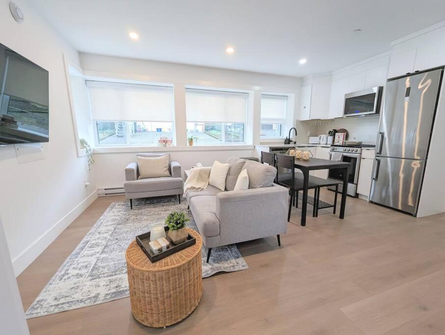 een woonkamer met een bank en een keuken bij Centrally located, modern, 2 bedroom home in Vancouver