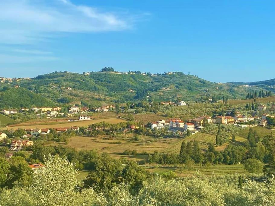 una pequeña ciudad en una colina con casas y árboles en Casa tranquilla colonica toscana vicino a Firenze, en Seano