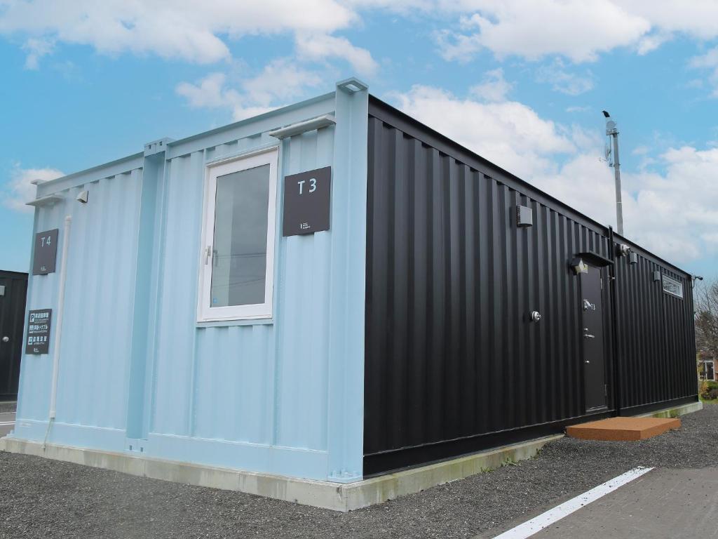 ein blaues und schwarzes Gebäude mit einem Fenster in der Unterkunft HOTEL KUTEKUN - Vacation STAY 31436v in Naka-shibetsu
