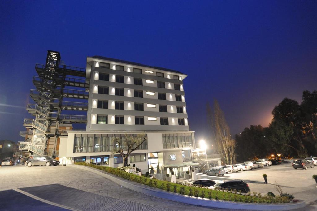 a building with cars parked in front of a parking lot at Park Hotel Sporting in Teramo