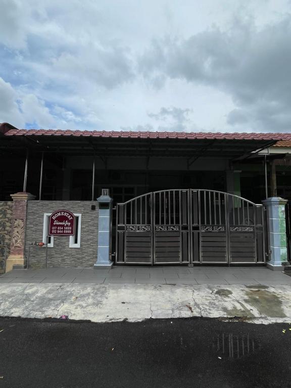 a building with a gate with a sign on it at Homestay ShimahJay Telok Mas Melaka in Melaka
