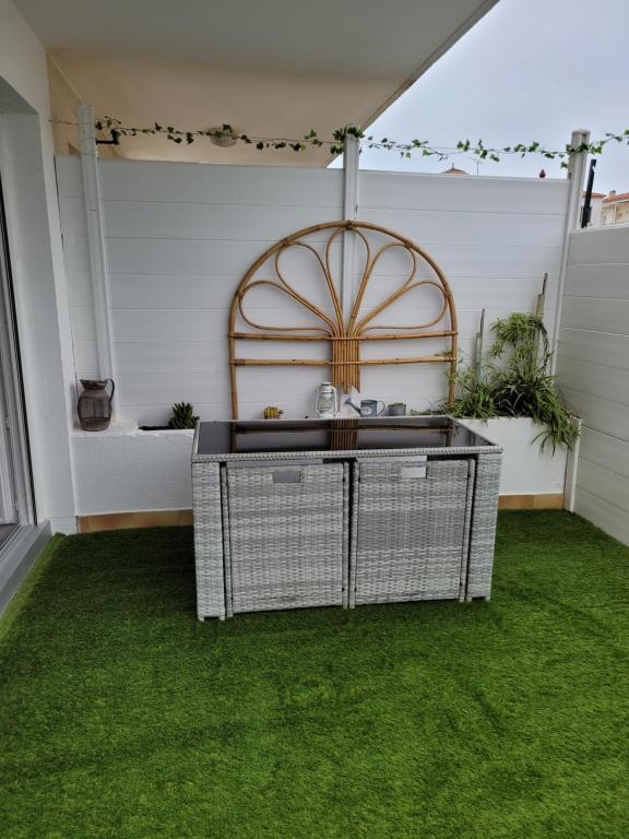 a covered patio with green grass and a table at Tahiti Beach in Frontignan