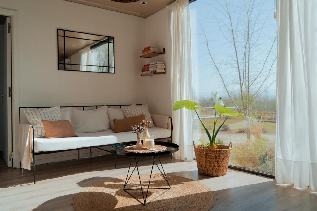 ein Wohnzimmer mit einem Sofa und einem großen Fenster in der Unterkunft Paso Calmo in Villa General Belgrano