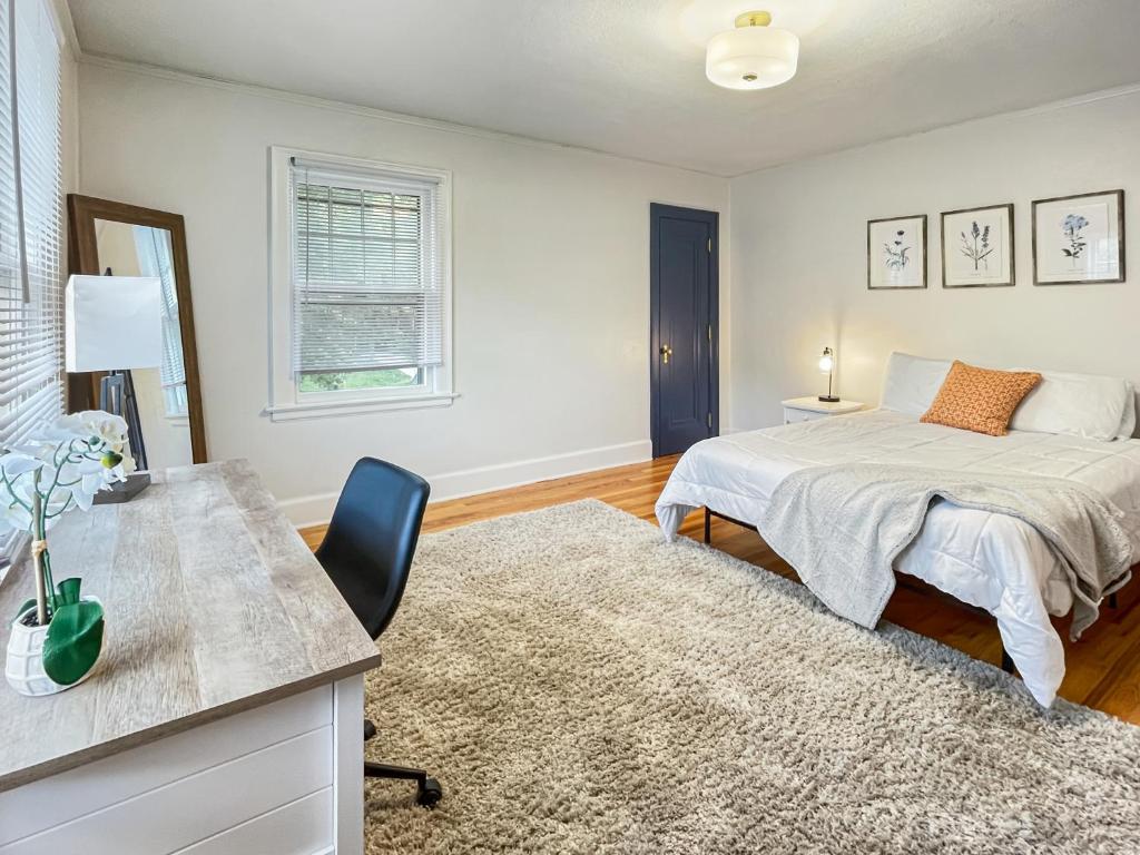 een slaapkamer met een bed en een bureau met een stoel bij 3 Br For 9 Guests -large Beautiful 3 Story Duplex in Des Moines