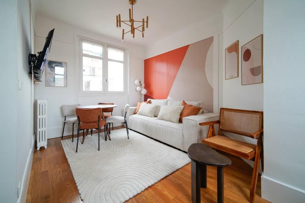 a living room with a couch and a table at Appartement Arc de Triomphe - Neuilly - II in Neuilly-sur-Seine