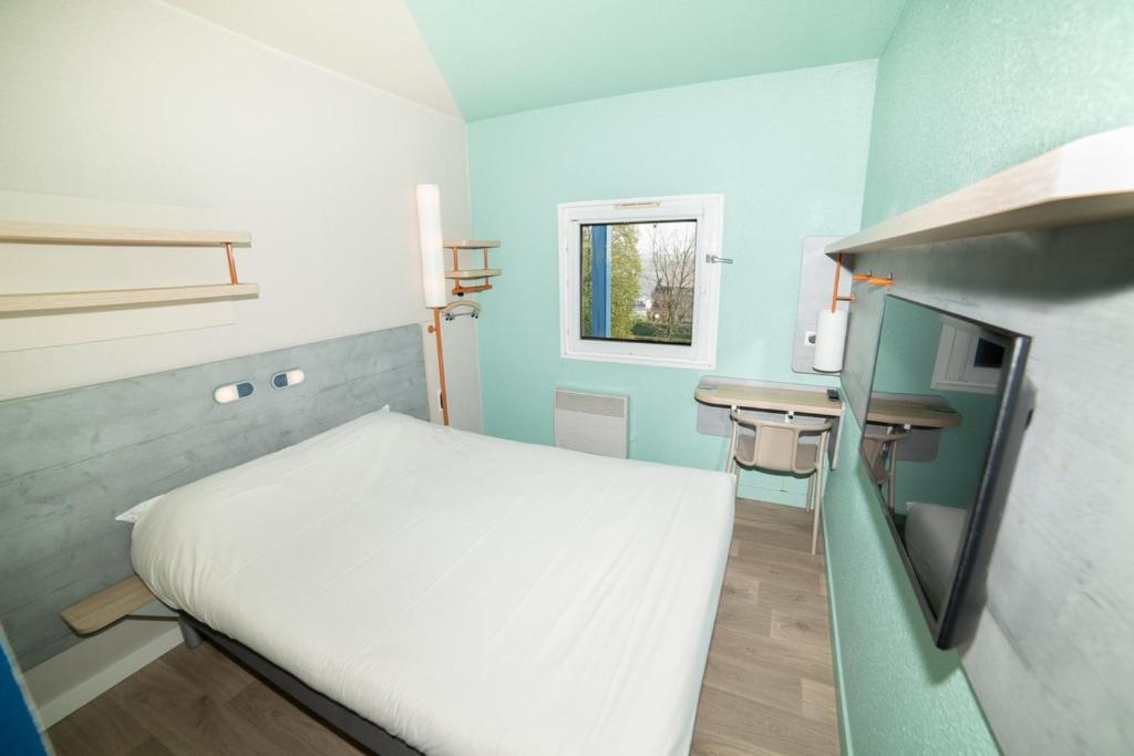 Habitación pequeña con cama y escritorio. en Accueil Hotel Besançon, en Besançon