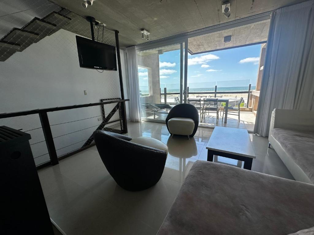 sala de estar con sofá, sillas y mesa en Linda Bay Spa Apartments en Mar de las Pampas