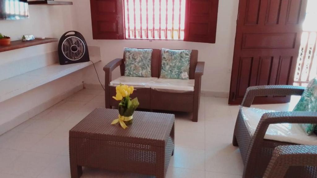 un soggiorno con divano, sedia e tavolo di Habitaciones Ciudad Amurallada a Cartagena de Indias