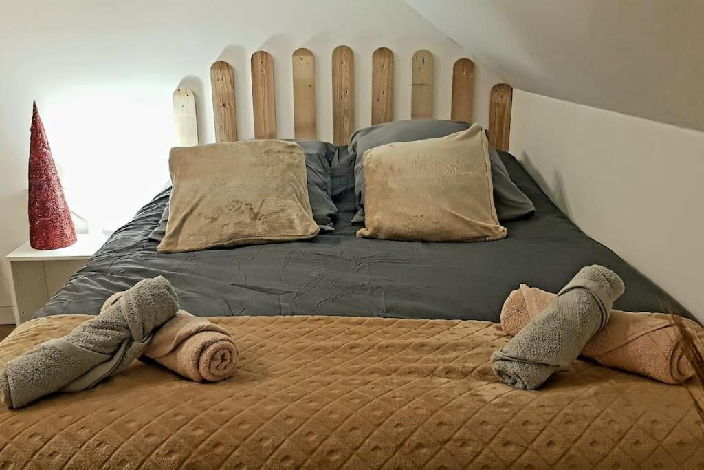 a bed with two towels on top of it at Le Sable d'Or - charme - détente in Amiens