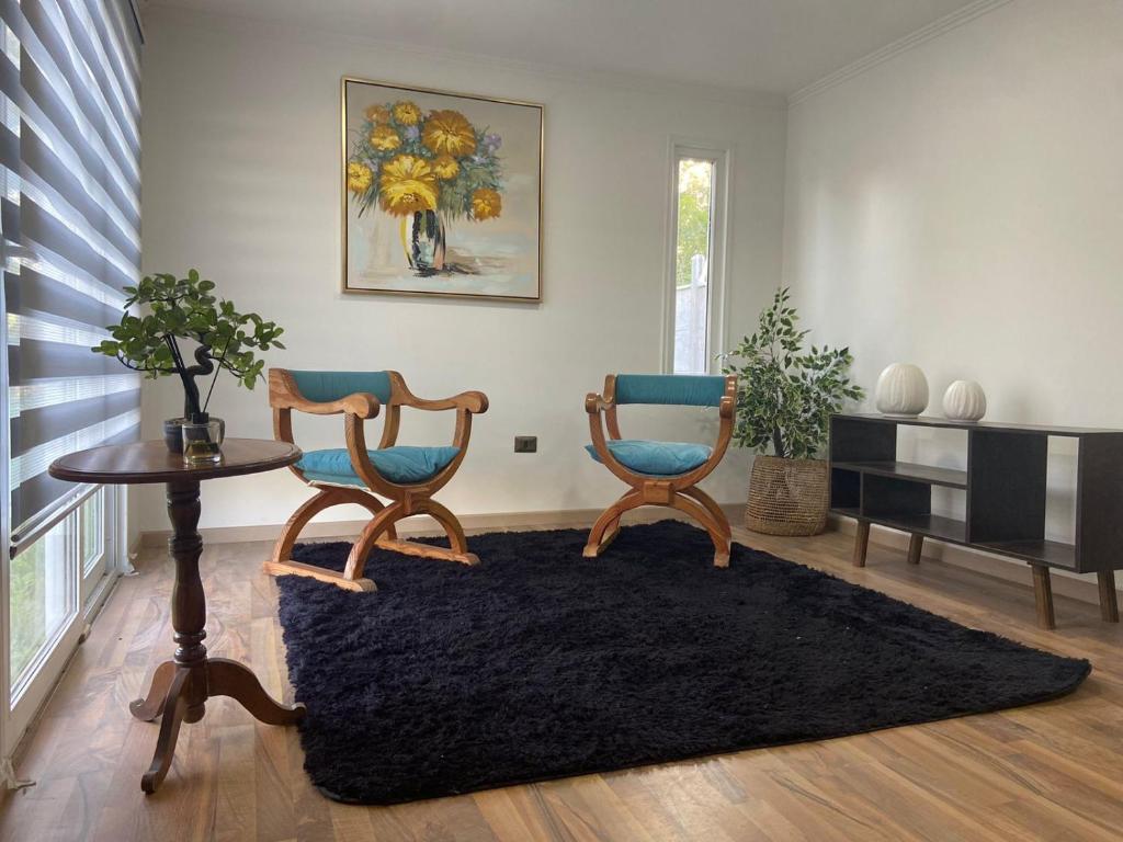 sala de estar con 2 sillas y mesa en Cabaña de Campo Las Hortensias, en Chimbarongo
