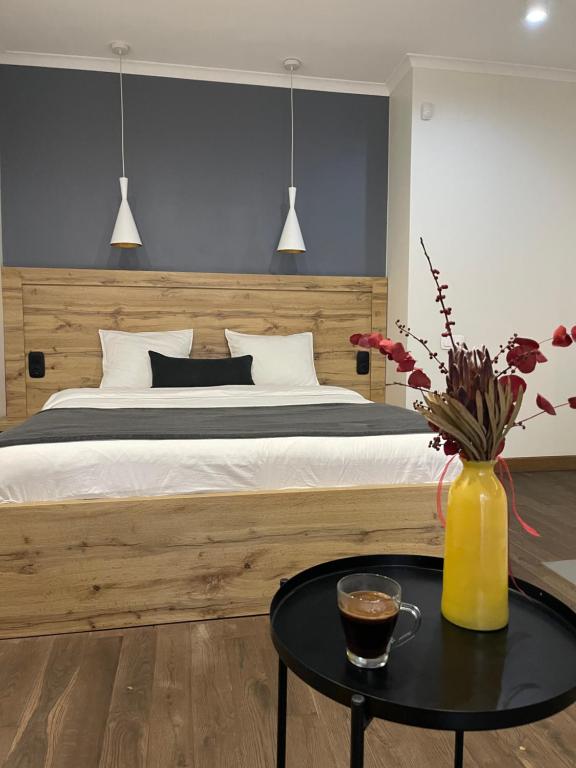 a bedroom with a bed and a table with a vase of flowers at SCANDIC apartments-feels like home! in Lviv