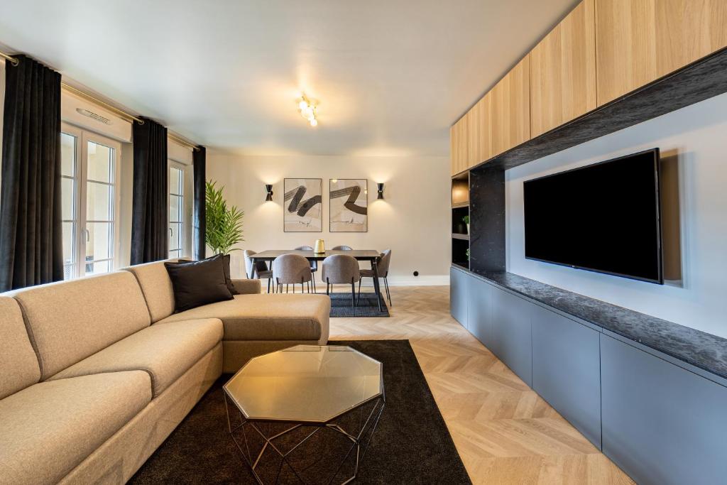 uma sala de estar com um sofá e uma televisão de ecrã plano em Suite d'Exception, Disneyland Paris, 6 personnes em Serris