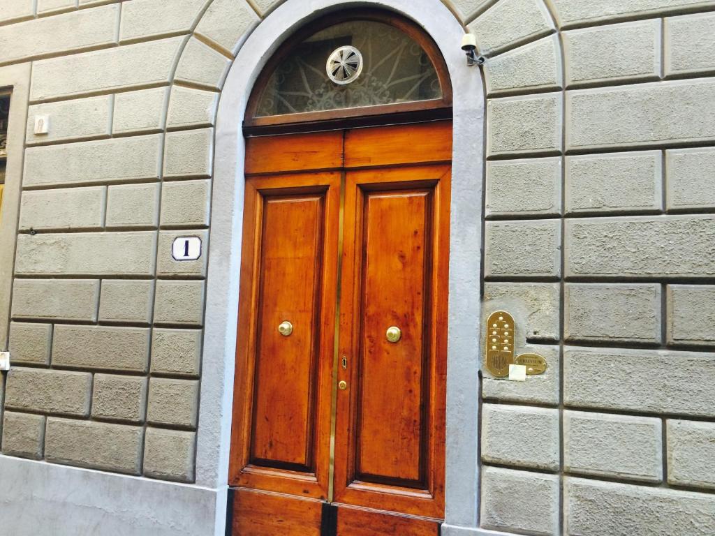 a wooden door in a brick building with a window at Soggiorno Oblivium in Florence