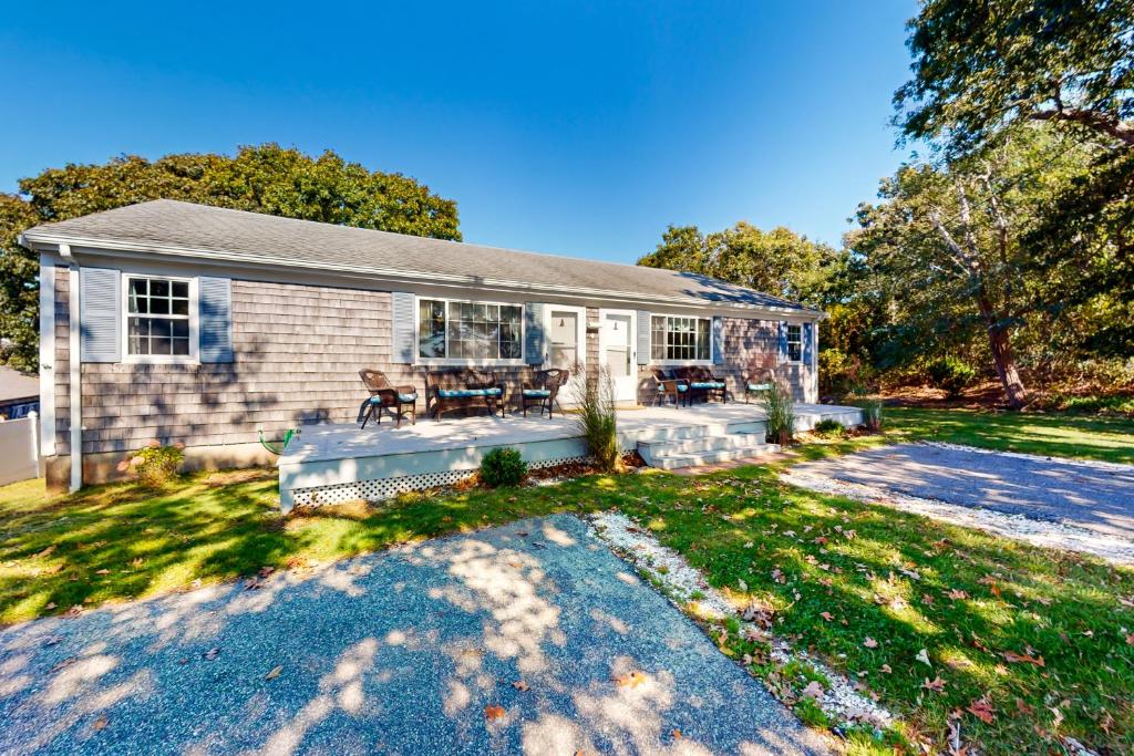 a home with a patio and a house at Sea View Revue - A in Dennis Port