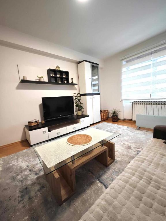 ein Wohnzimmer mit einem TV und einem Couchtisch in der Unterkunft SarajVista in Sarajevo