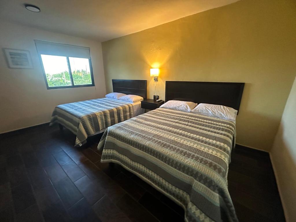 a hotel room with two beds and a window at FIESTA MIRAMAR in Ciudad Madero