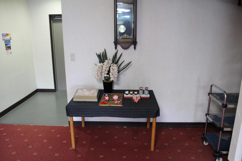 a table in a room with a vase of flowers at Yamadaya Hotel in Fujikawaguchiko