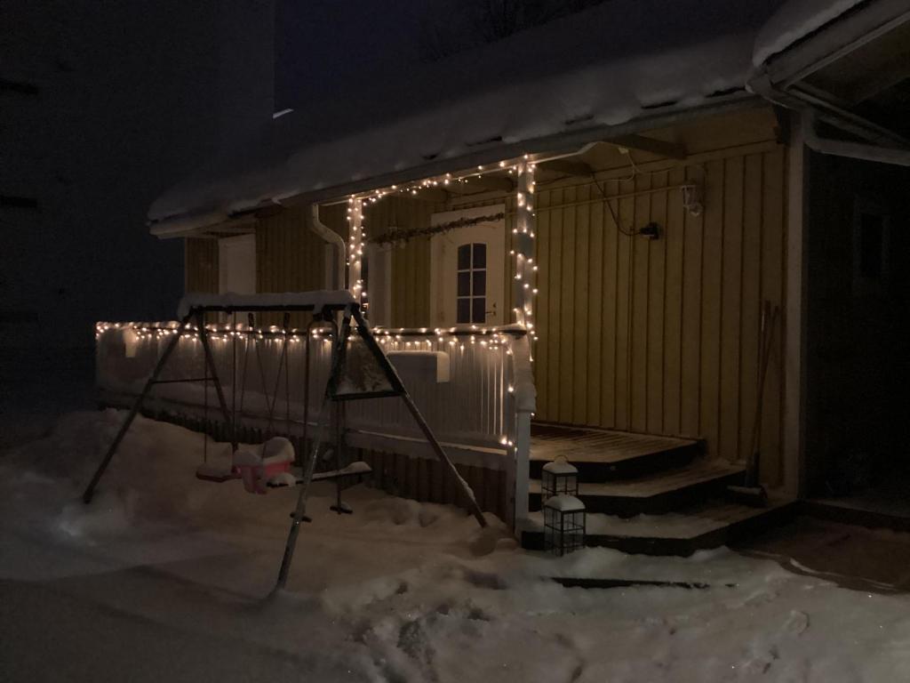 ein Haus mit Weihnachtslichtern im Schnee in der Unterkunft Lapland winter cottage in Rovaniemi