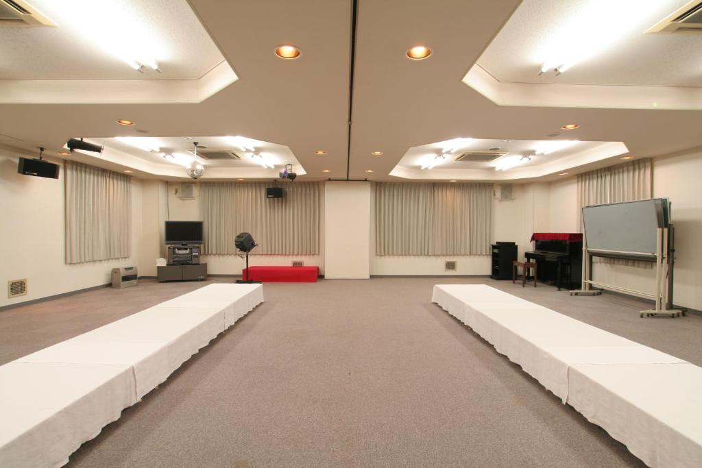 a large room with a stage and a screen at Yamadaya Hotel in Fujikawaguchiko