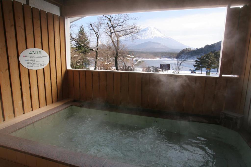 a jacuzzi tub with a view of a mountain at Yamadaya Hotel in Fujikawaguchiko