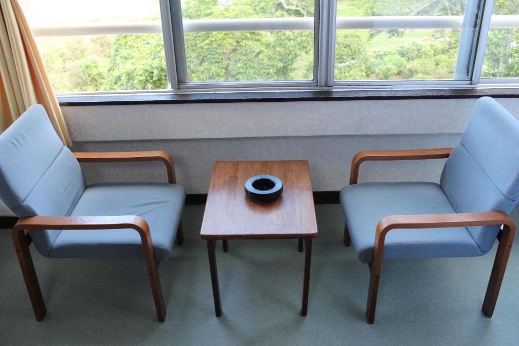 two chairs and a table in a room with a window at Yamadaya Hotel in Fujikawaguchiko