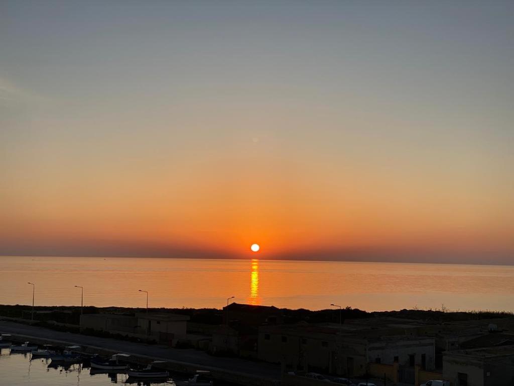 a sunset over the water with the sun setting at Un Letto sul Mare (vit vit vit) in Marsala