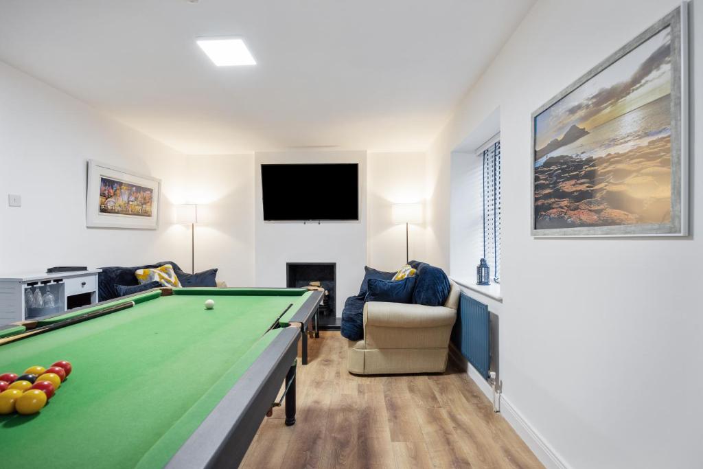 uma sala de estar com uma mesa de bilhar e uma televisão em Ballycastle Bolthole em Ballycastle