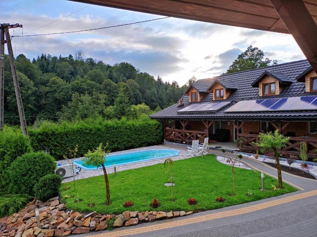 an aerial view of a house with a swimming pool at Jaśkowa Chata Bieszczady apartament z basenem in Baligród