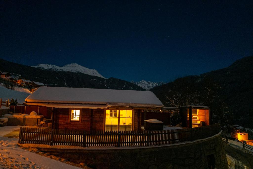 a log cabin in the mountains at night at Chalet Hittli 1065 - secret spot for unique vacay - inkl Gästekarte in Fliess