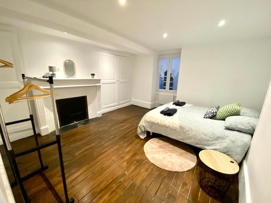 a living room with a bed and a fireplace at Maison individuelle atypique sur 2 étages in Bar-sur-Aube