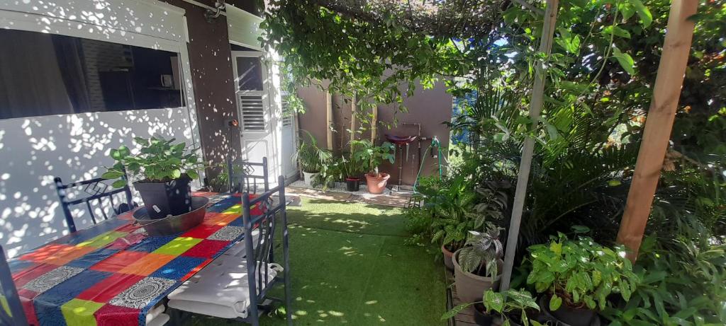 a garden with a colorful blanket on a porch at Le LiloVert - Studio 24 m2 in Le Carbet