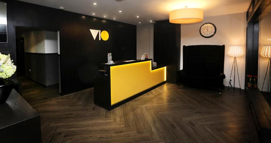 einen Salon mit gelber Theke und Uhr in der Unterkunft Vio Hotel in Kuala Lumpur
