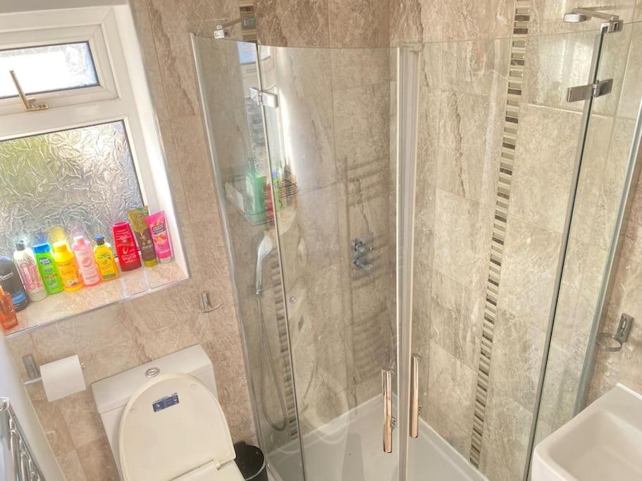 La salle de bains est pourvue d'une douche, de toilettes et d'un lavabo. dans l'établissement Watford cottage holiday house, à Abbots Langley