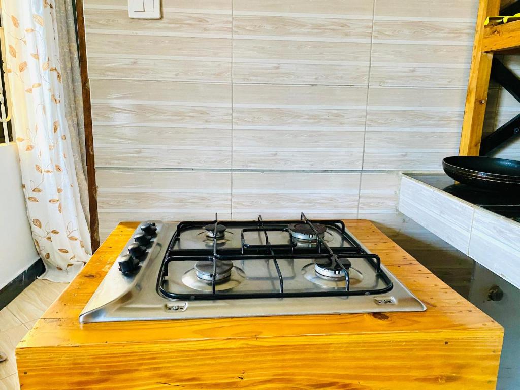 a stove top oven sitting on top of a wooden table at Tin apartment Tanga in Tanga