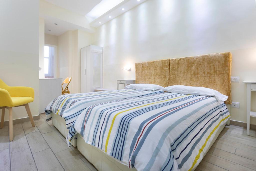 1 dormitorio con 1 cama y 1 silla amarilla en Il Guardinfante - Camera indipendente con bagno privato, en Turín