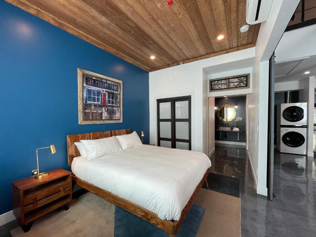 1 dormitorio con cama y pared azul en Petaluma Warehouse Lofts unit E, en Petaluma