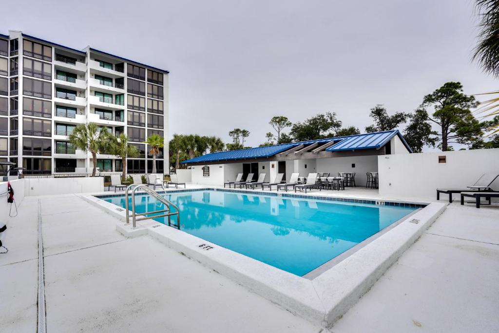 a swimming pool in front of a building at Florida Apartment with Balcony, Pool Access and Views in Panama City Beach