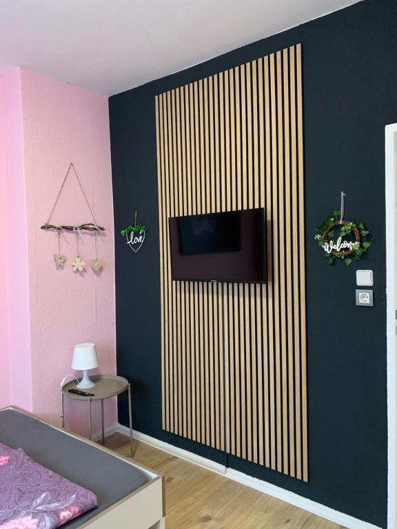 Zimmer mit einem TV an der Wand in der Unterkunft Just Berlin - Wohnung für bis zu 12 Personen in Berlin