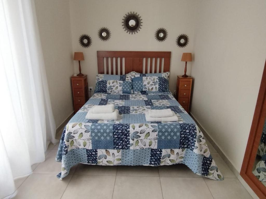 1 dormitorio con 1 cama con edredón azul y espejos en ★★APARTAMENTOS MARIN★★, en Alicante