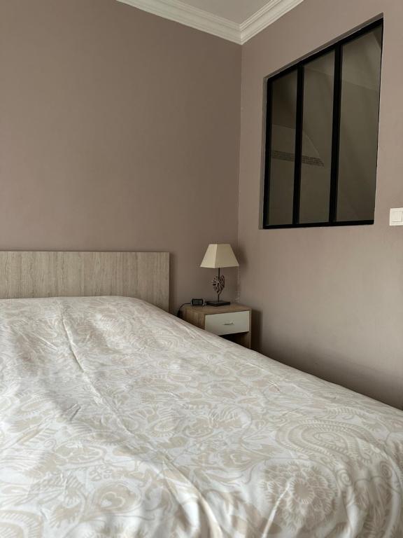 una camera da letto con un grande letto bianco e una finestra di Appartement Cosy a Lamorlaye