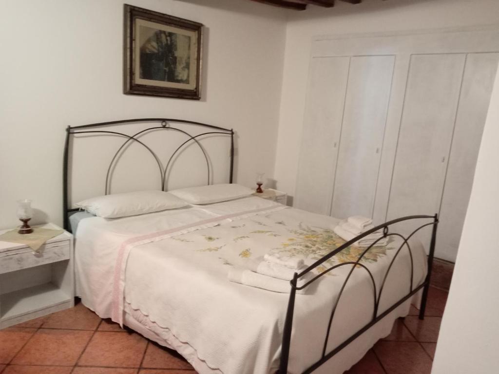 1 dormitorio con 1 cama blanca con marco metálico en Camera Vacanze Lusitana C, en Foligno