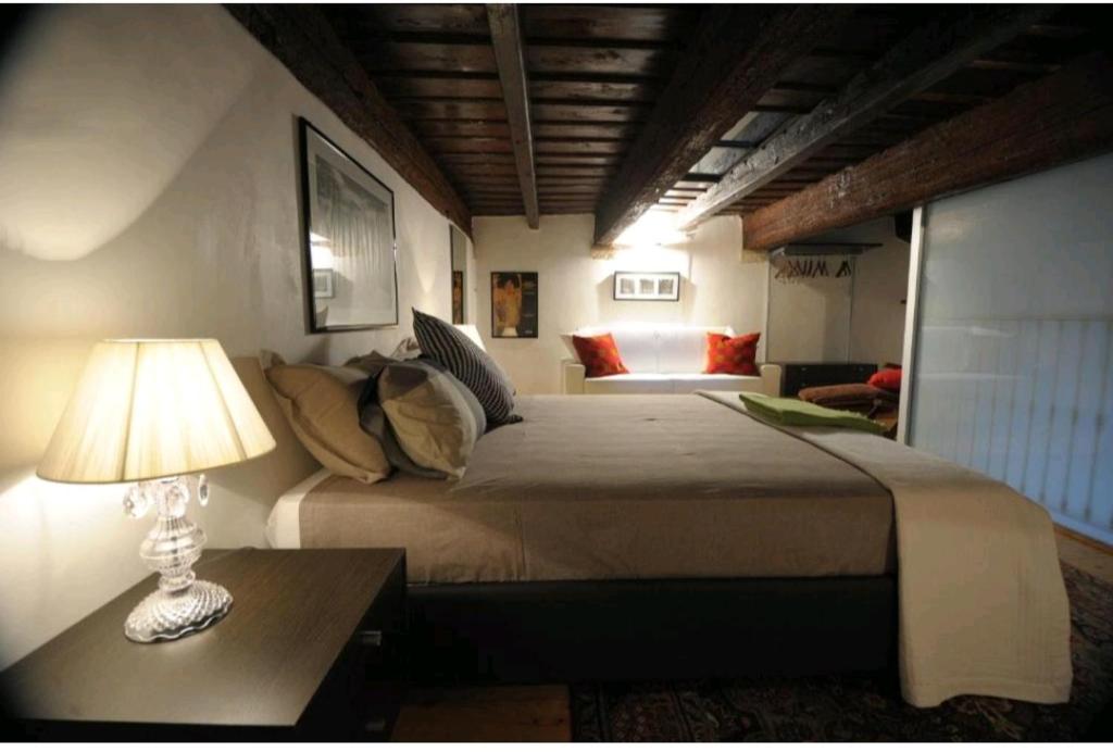 a bedroom with a bed and a table with a lamp at Saint Patrick-Guest House Del 1200 in Barletta