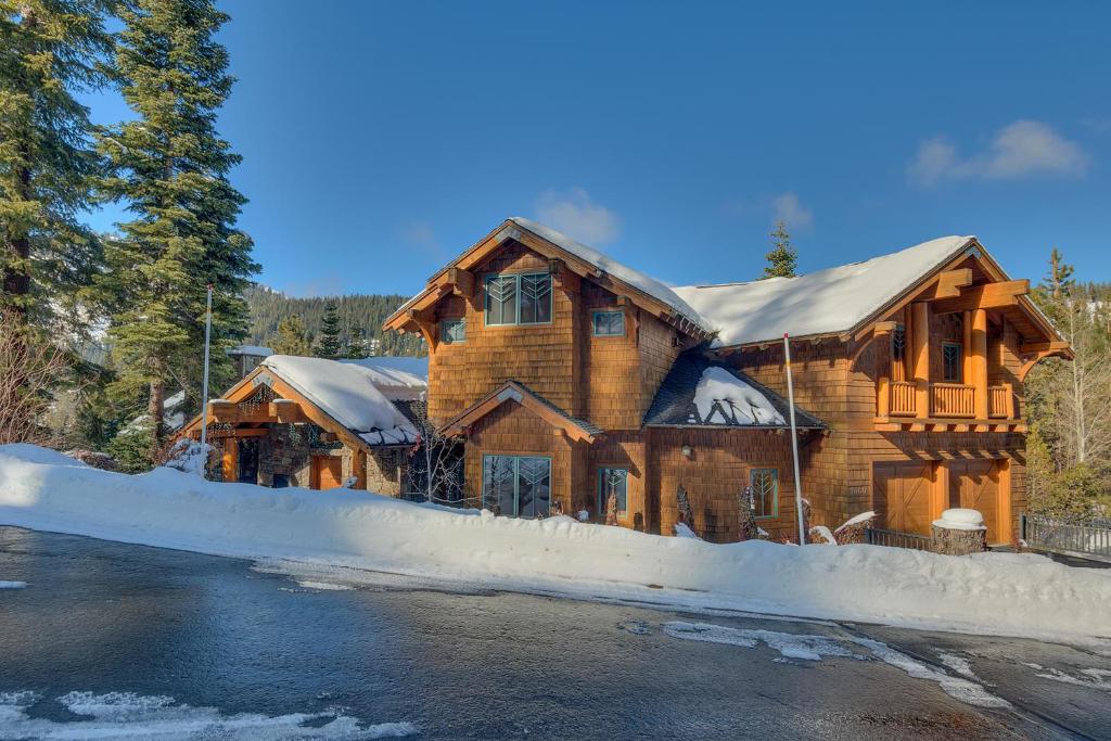 duży drewniany dom z śniegiem na ziemi w obiekcie Sundance Lodge -Mountain Home w Views of Palisades - Ski Shuttle, Pets okay! w mieście Olympic Valley