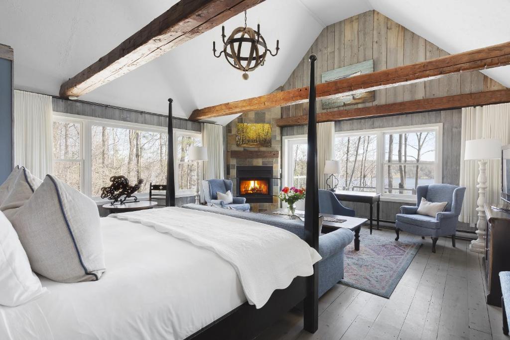 - une chambre avec un grand lit et une cheminée dans l'établissement Manoir Hovey, Relais & Châteaux, à North Hatley