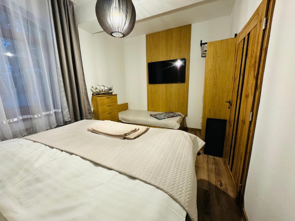 Habitación de hotel con 2 camas y TV de pantalla plana. en Apartmány KAMZÍK Donovaly, en Donovaly