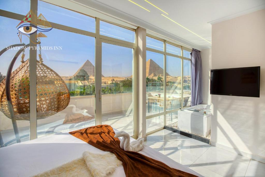 a bedroom with a large window with a view of the pyramids at Shadow Pyramids Palace in Cairo