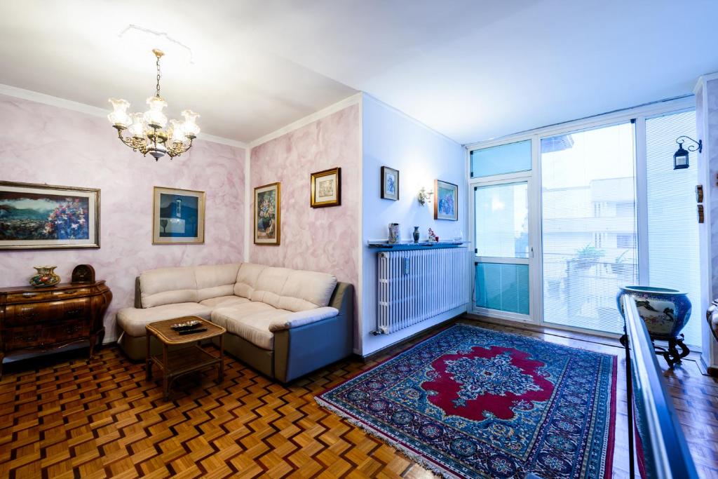 a living room with a couch and a window at Rètro Apartment In The Mountains in Mezzolombardo