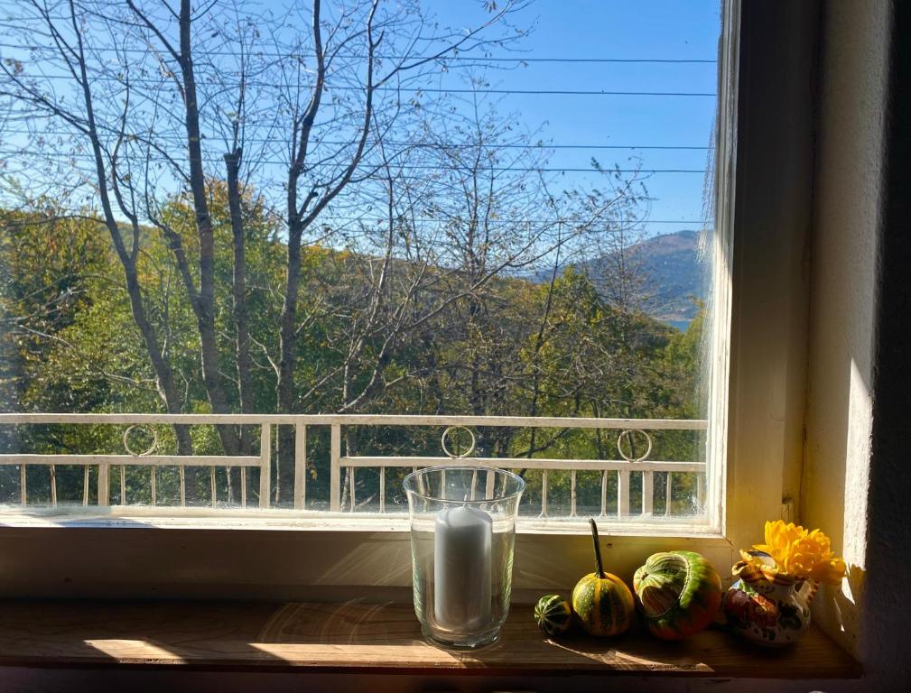 ein Fenster mit einer Kerze und ein paar Kürbissen auf einem Fensterbrett in der Unterkunft Leunovo Adventure Villa in Leunovo