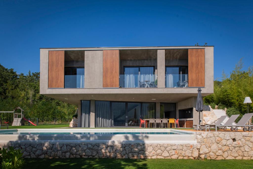 a house with a swimming pool in front of it at ARGENTO RESIDENCE in Zagvozd