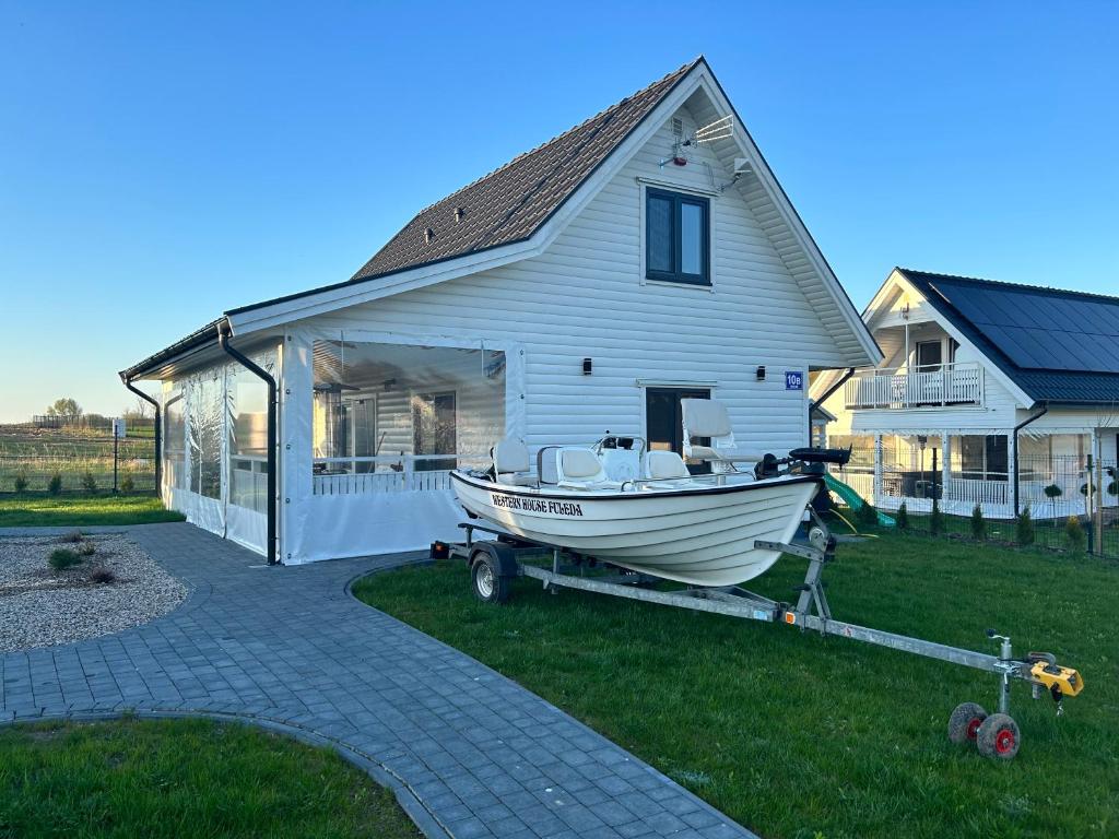 a boat on a trailer in front of a house at Domek Całoroczny Fuleda -Mazury Giżycko Sauna Jacuzii Kominek in Giżycko